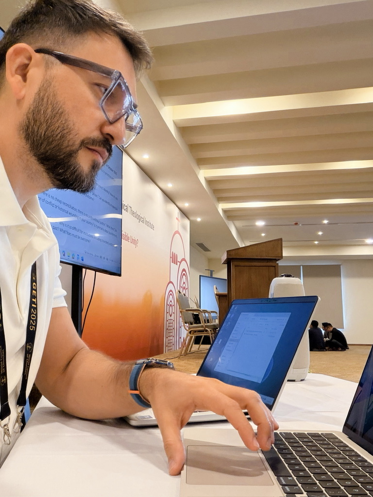 David working on a laptop at a conference