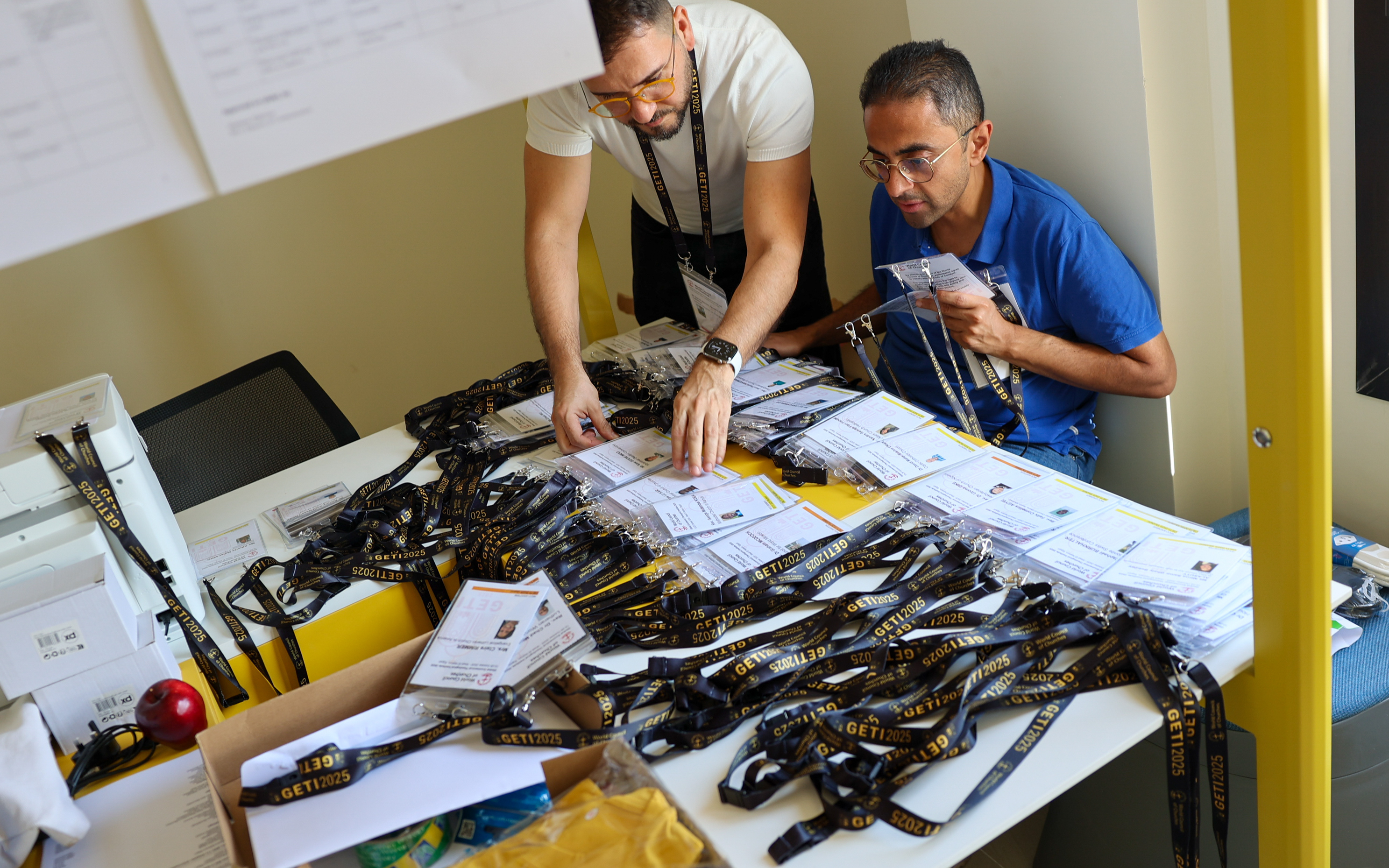 David sorting credentials at a registration table